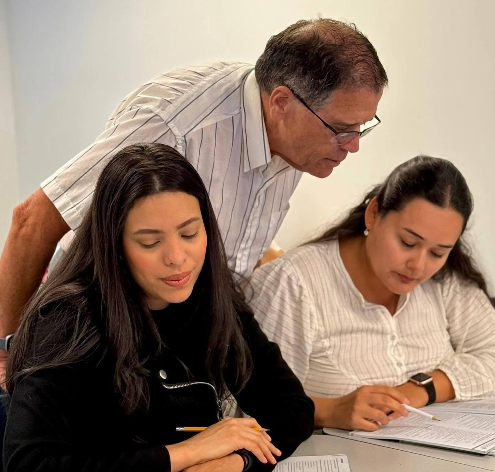Instrutor de TOEFL revisando exercícios de speaking com um estudante.