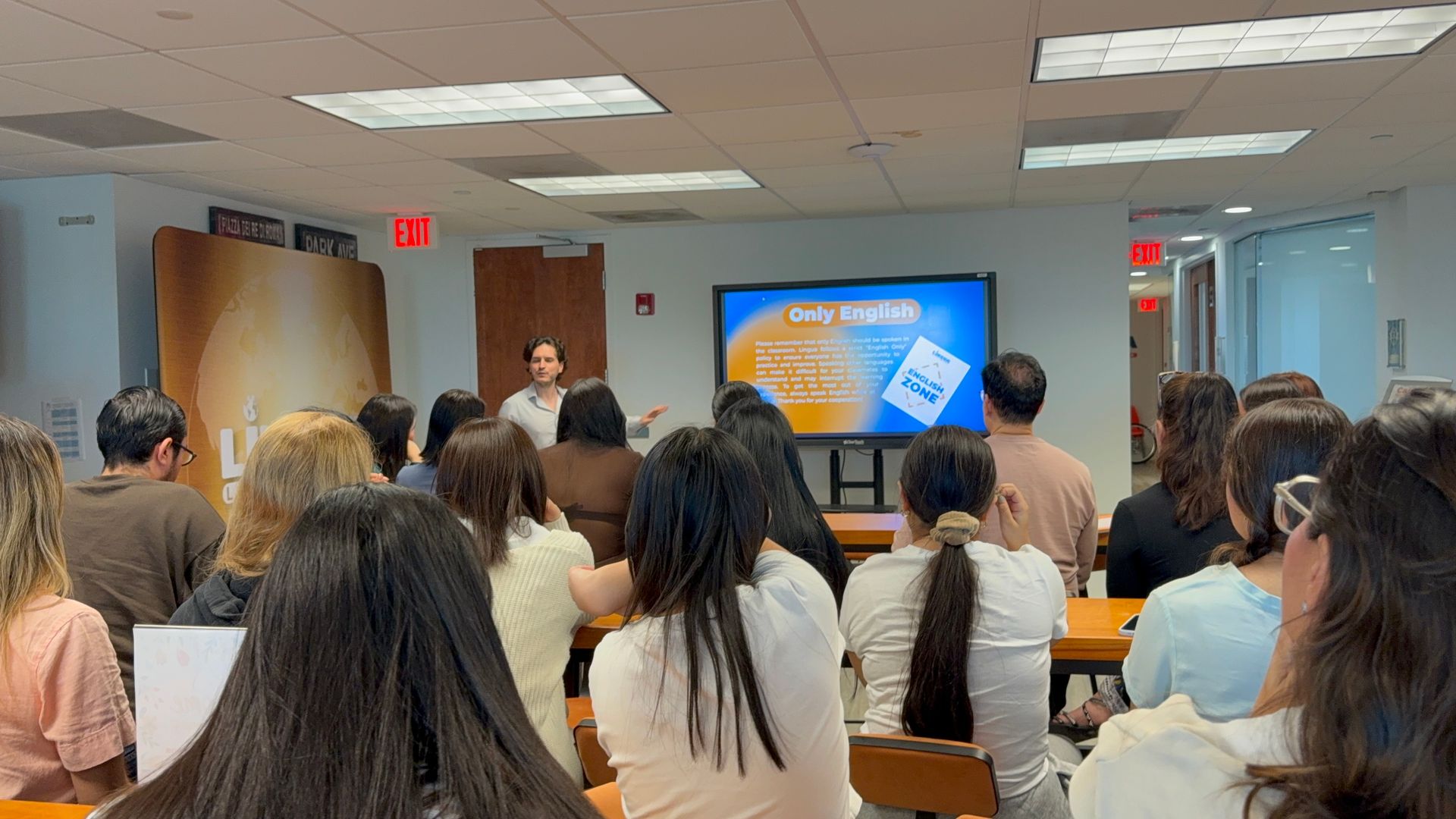 Audience seated in a room watching a presentation on a large screen