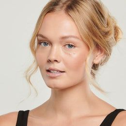 A close up of a woman 's face wearing a black tank top.