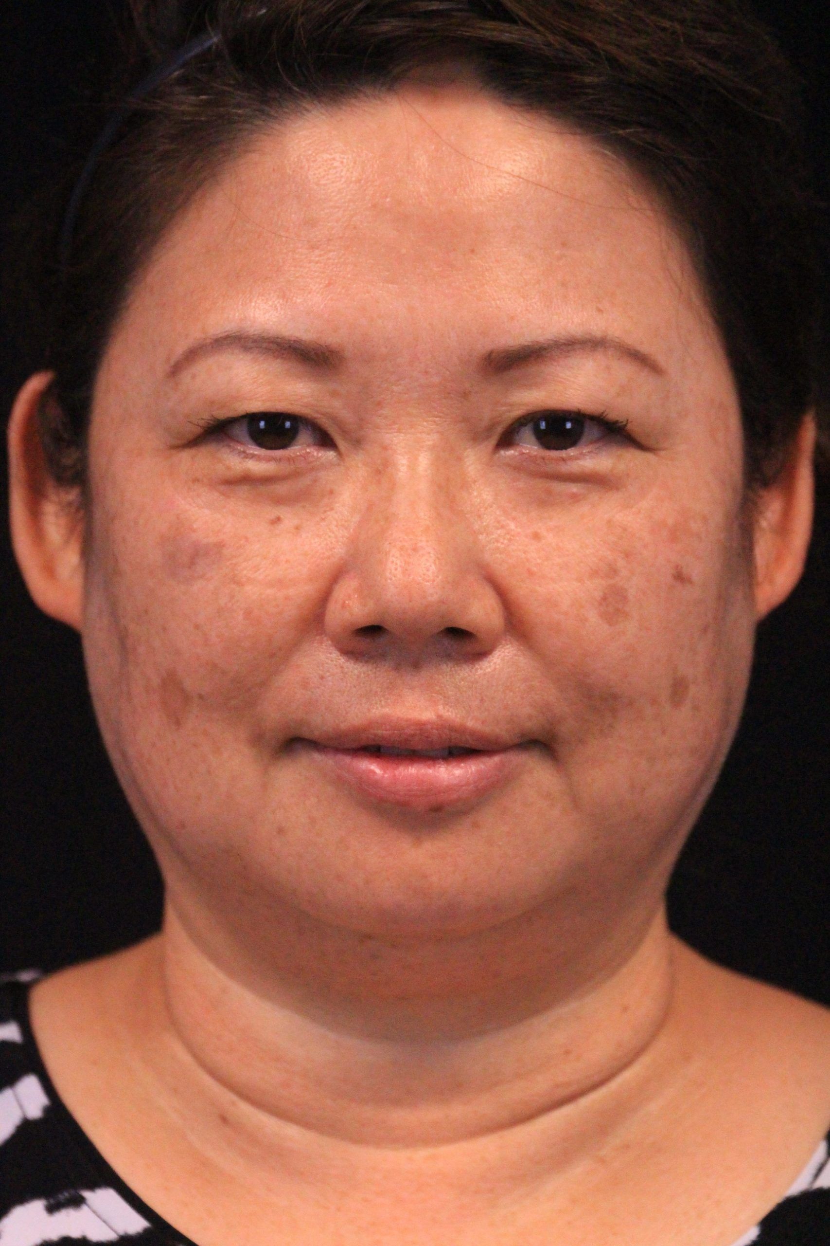 A close up of a woman 's face with a black background.
