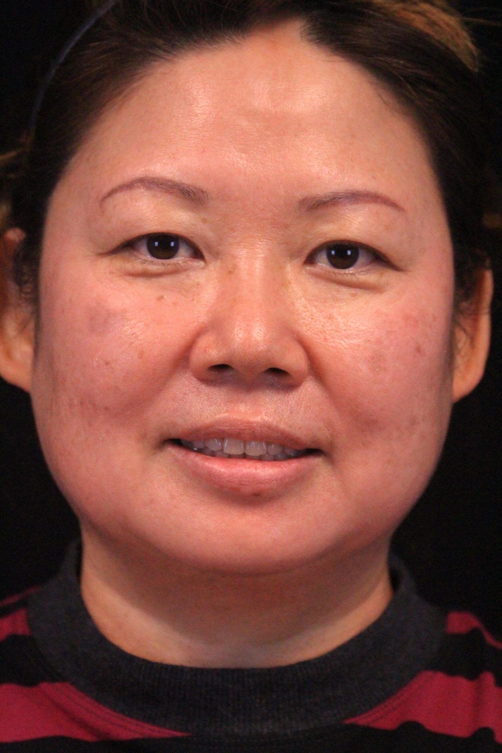 A close up of a woman 's face with a smile on her face.