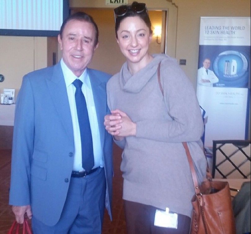 A man in a suit and tie stands next to a woman