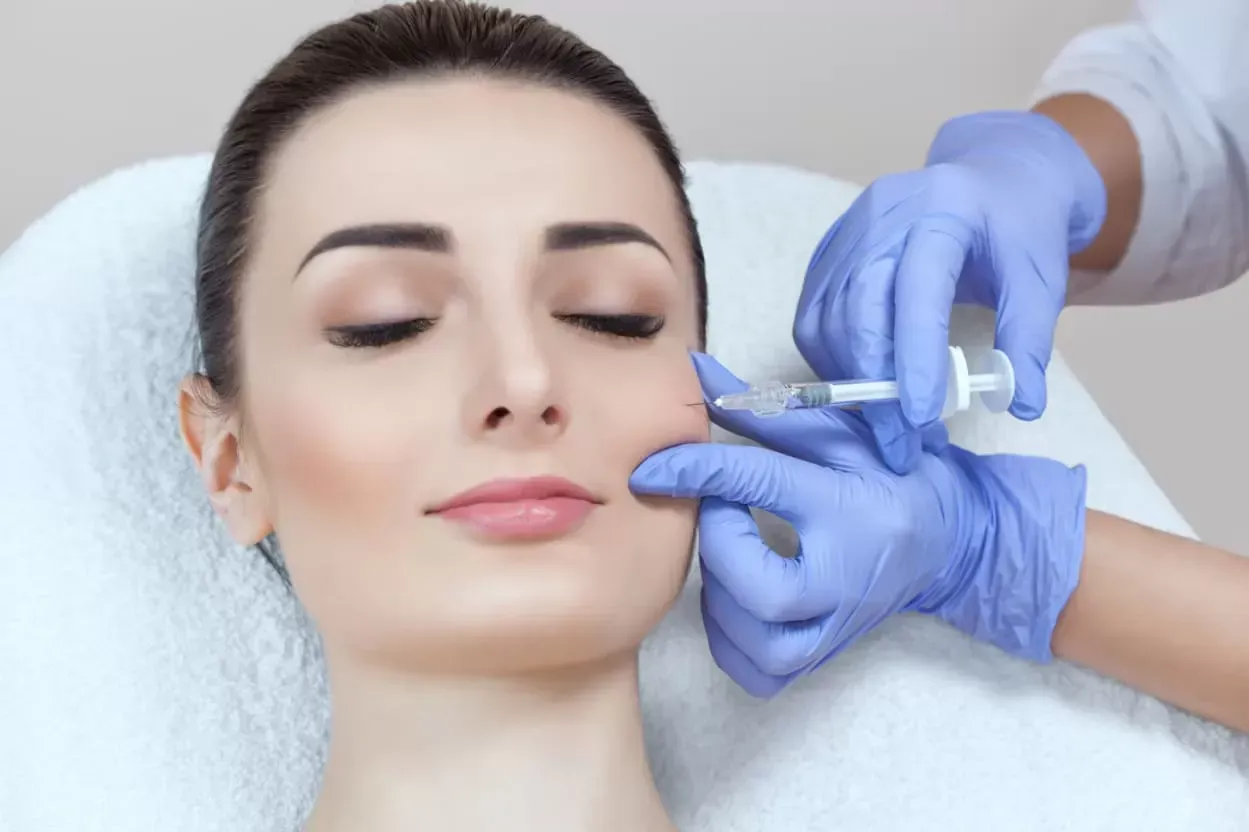 A woman is getting a botox injection in her face.