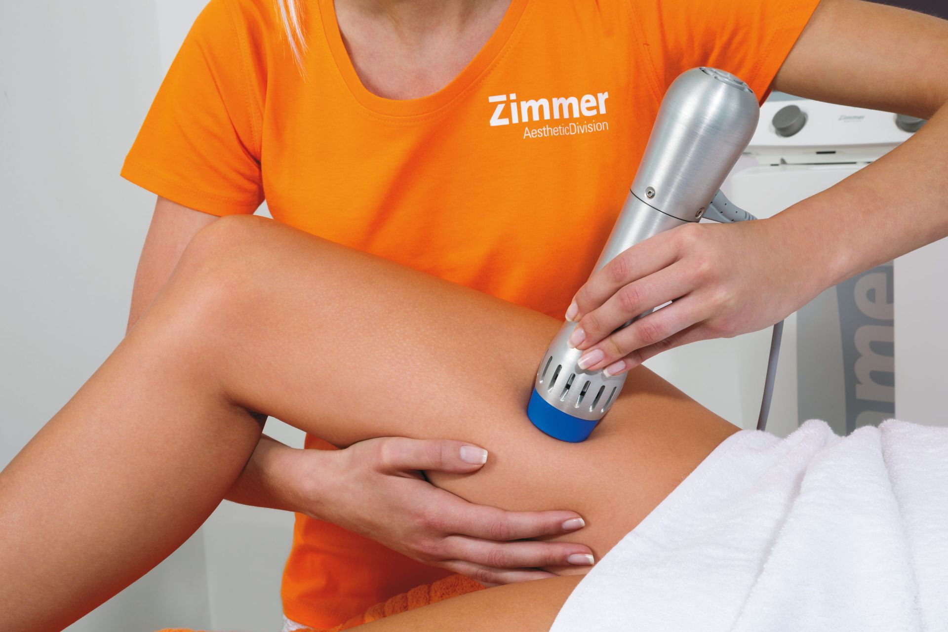 A woman wearing an orange shirt with the word zimmer on it