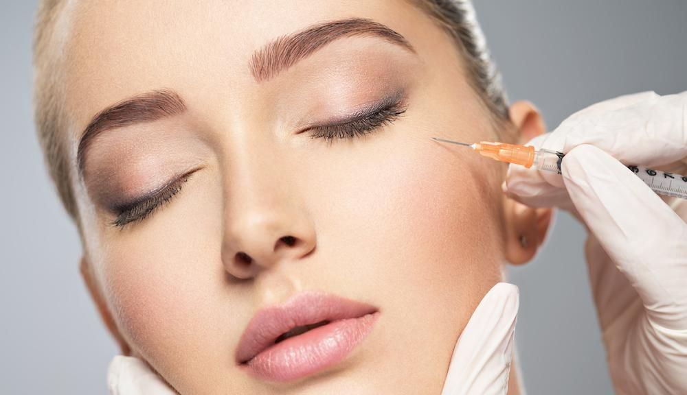 A woman is getting a botox injection in her face.