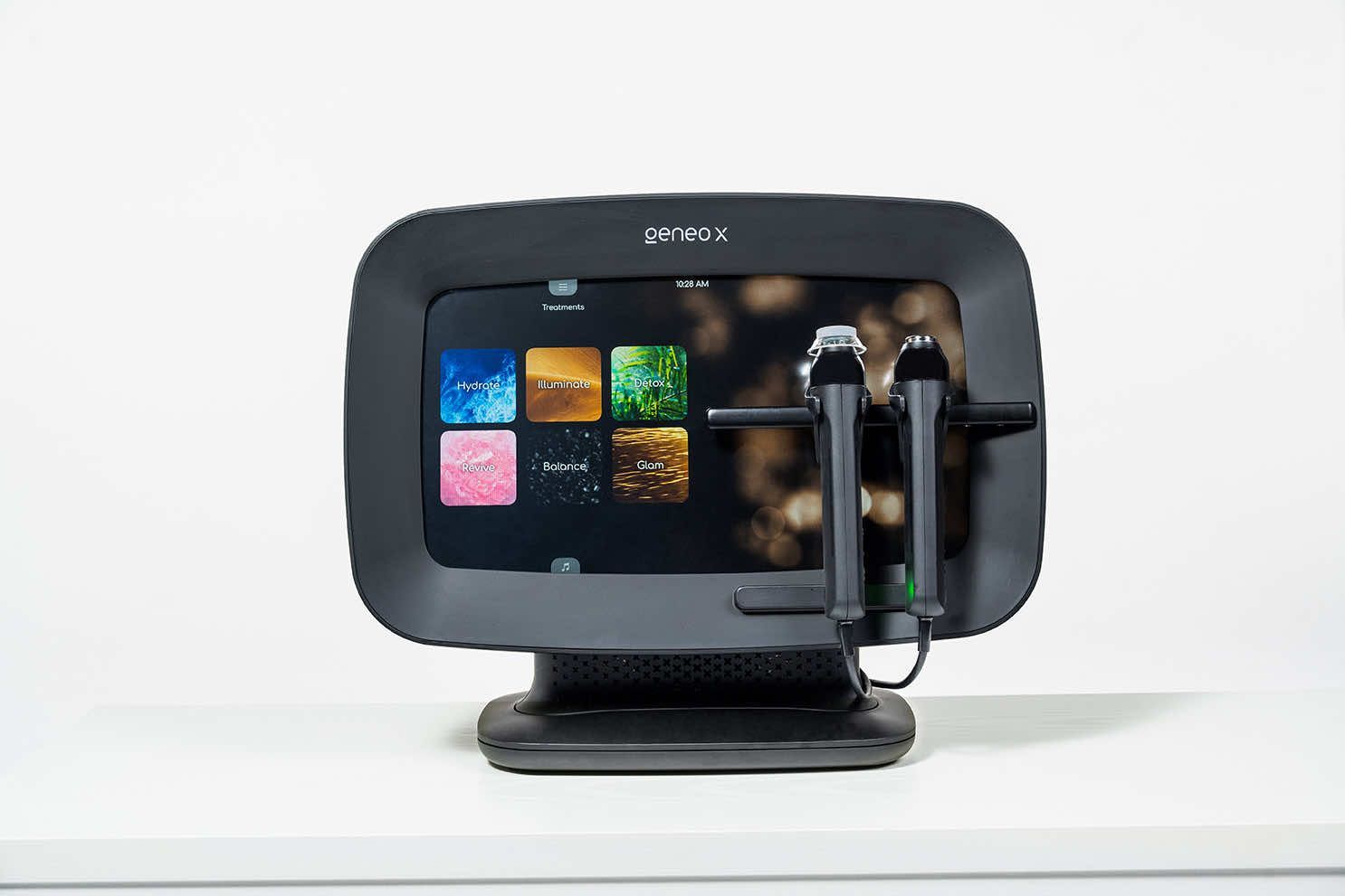 A computer monitor with two microphones attached to it is sitting on a table.