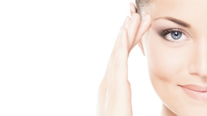 A close up of a woman 's face with her hand on her forehead.