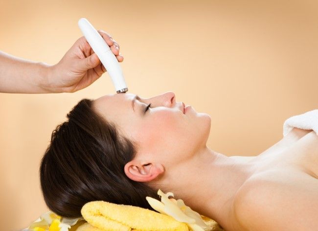 A woman is getting a facial treatment at a spa.