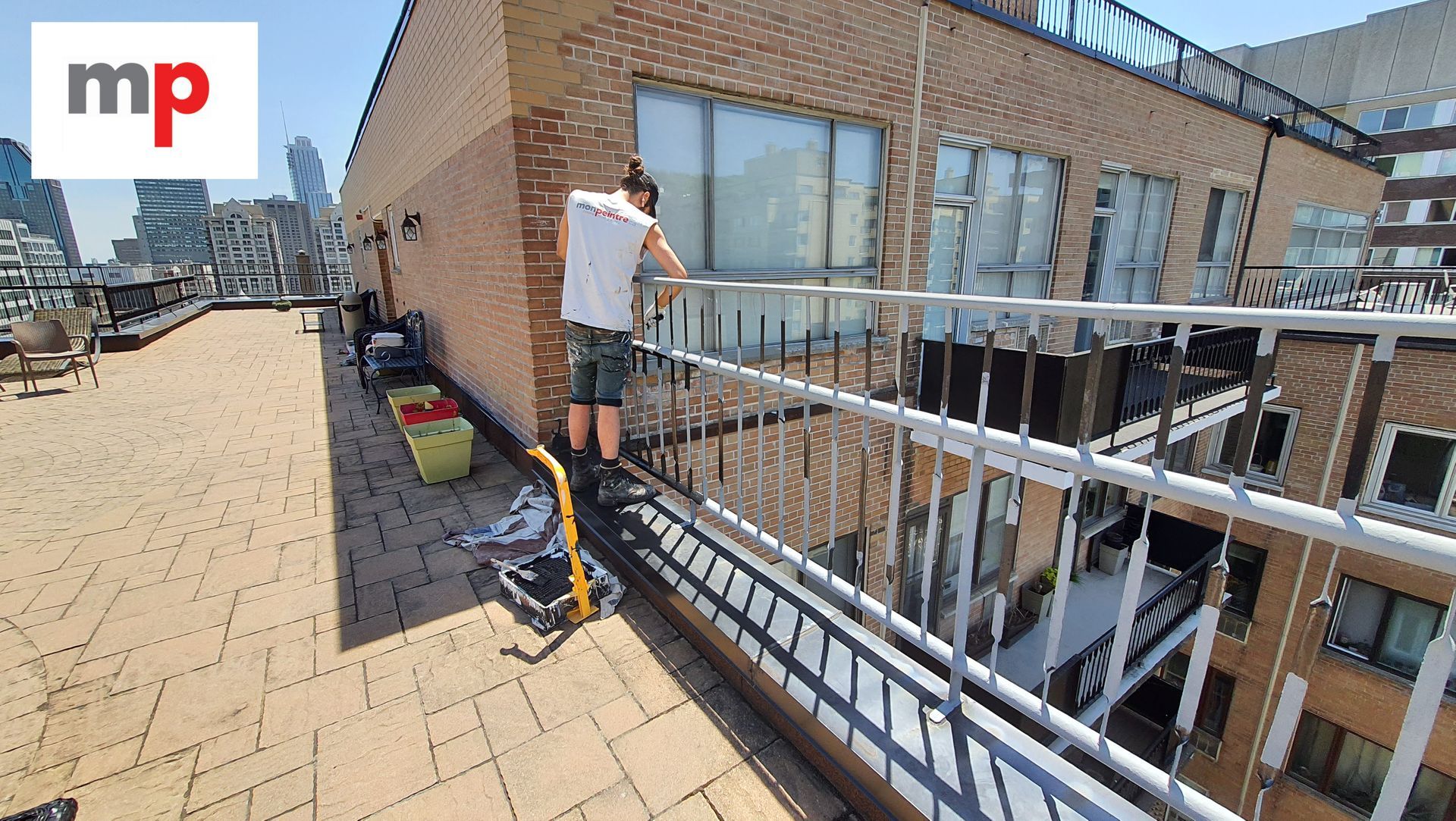 Un homme se tient debout sur un balcon donnant sur une ville.