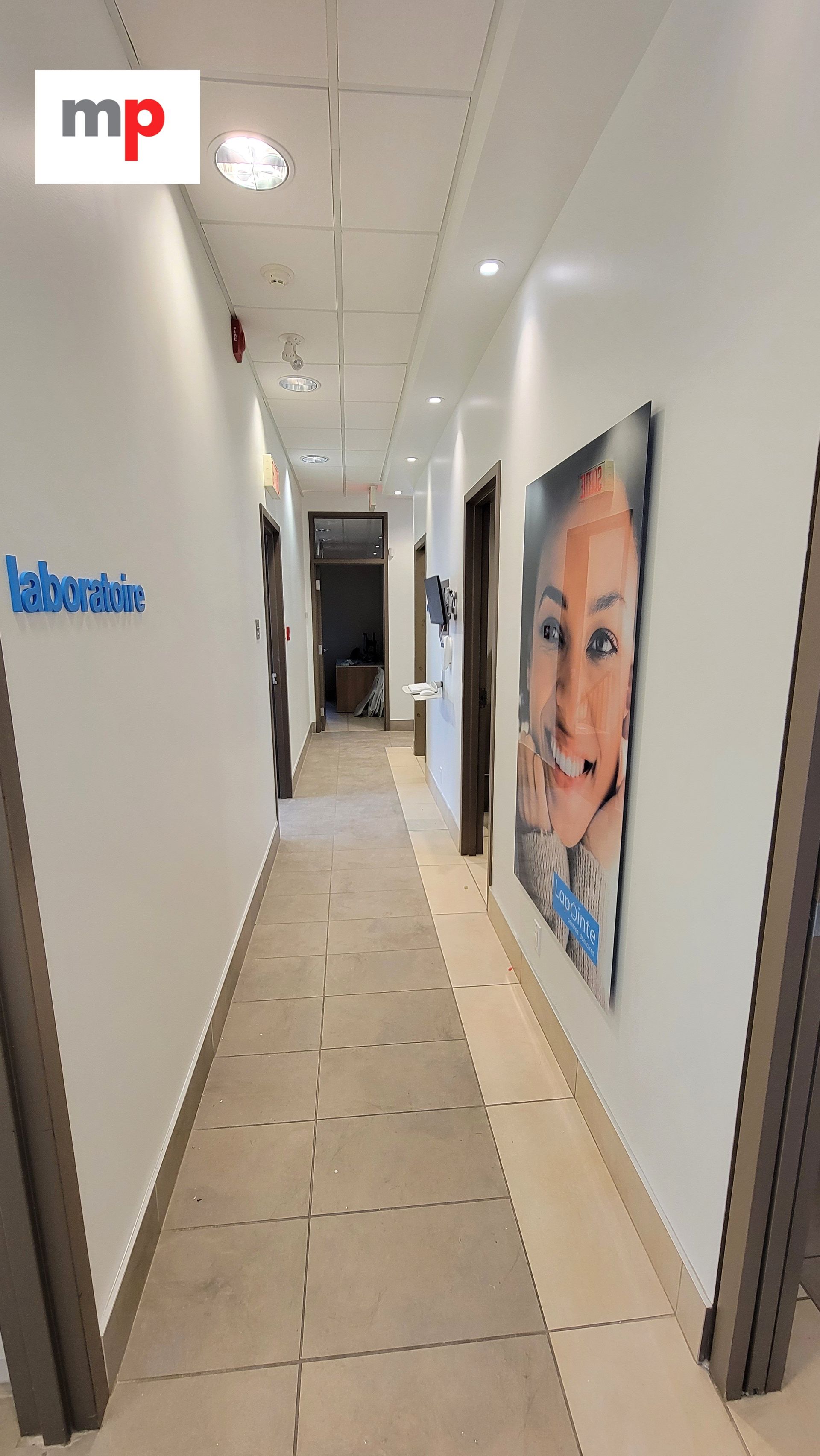 Couloir laboratoire avec affiche visage souriant