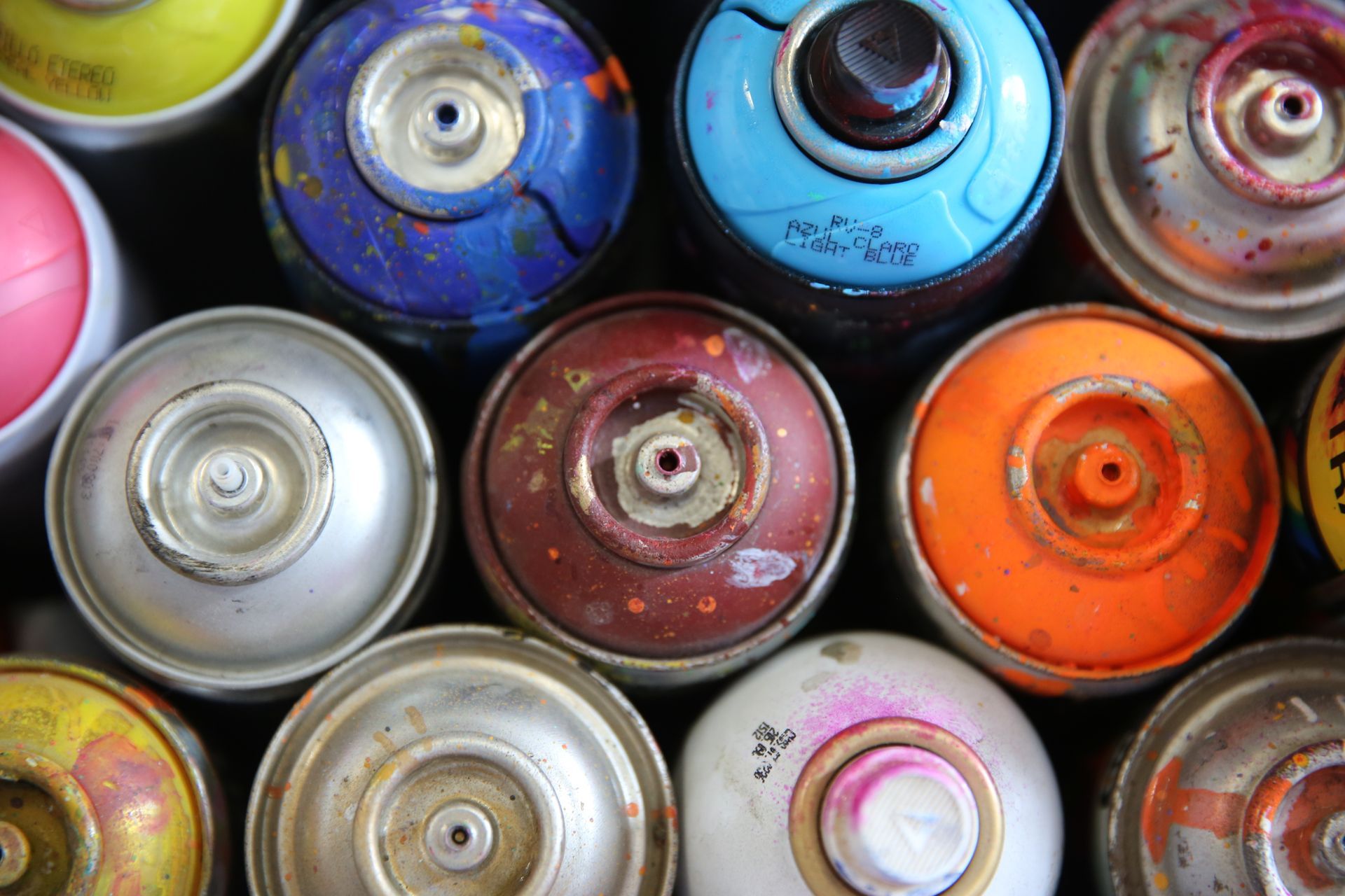 Un tas de bombes de peinture sont posées les unes sur les autres.
