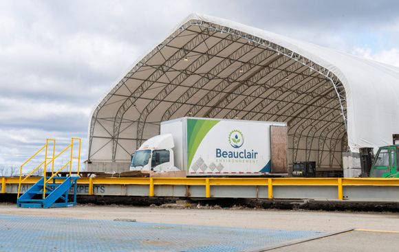 Un camion est assis sur une balance sous une tente.