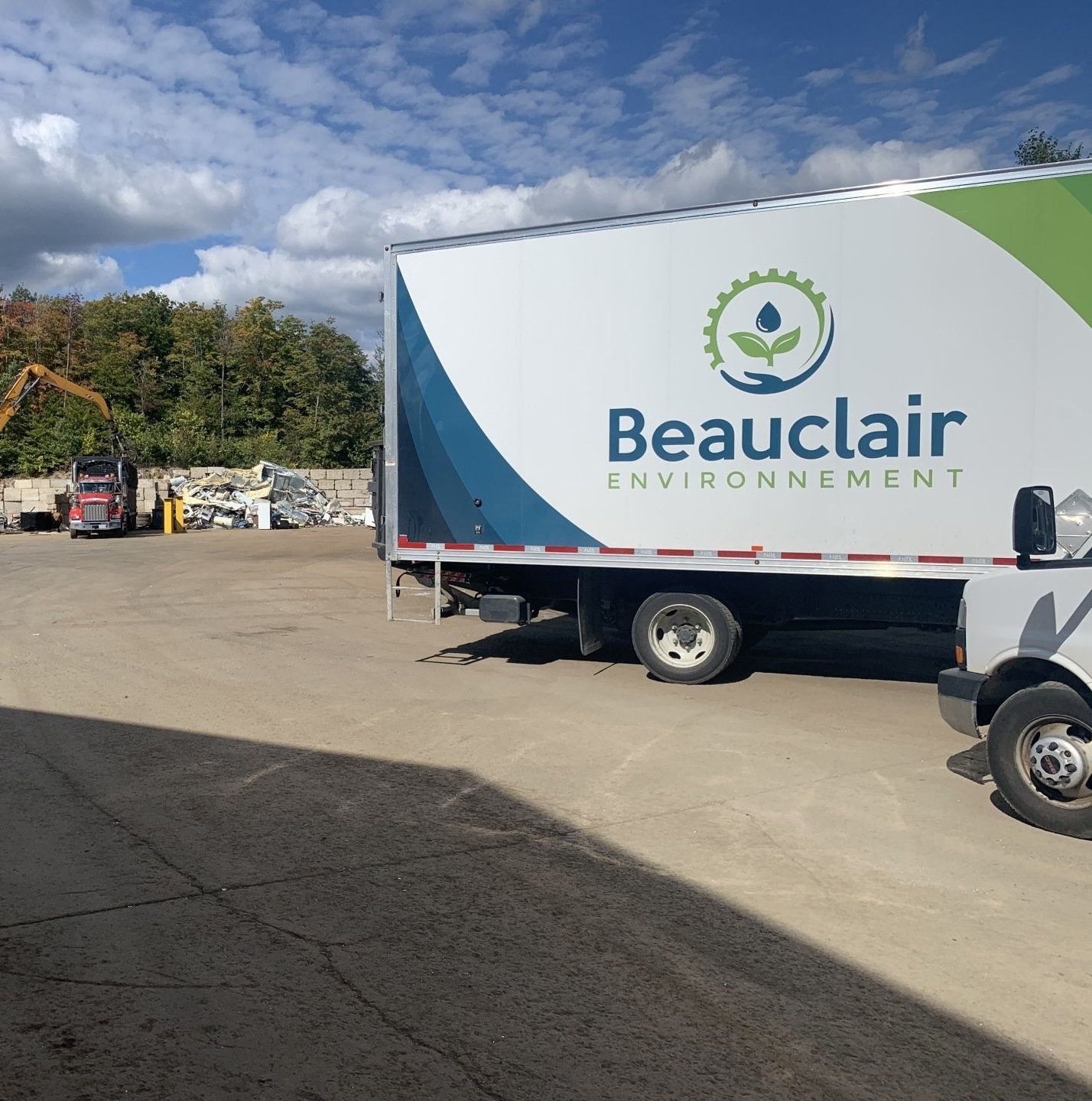 Camion blanc avec le logo « Beauclair Environnement » stationné dans une installation de recyclage.