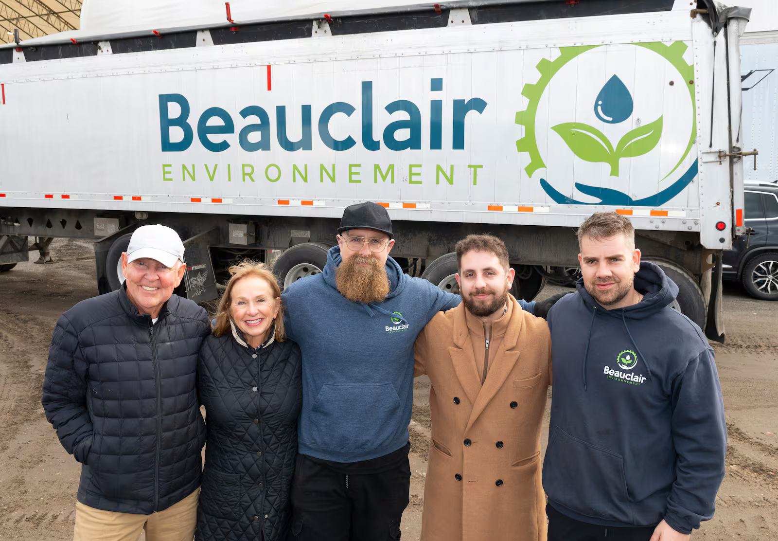 Groupe de cinq personnes posant devant un camion de Beauclair Environnement.