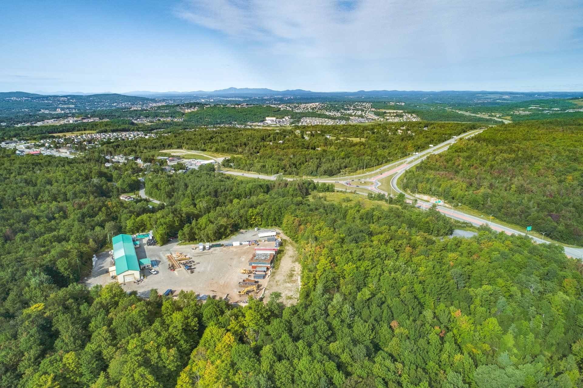 Une vue aérienne d une forêt avec un bâtiment au milieu.