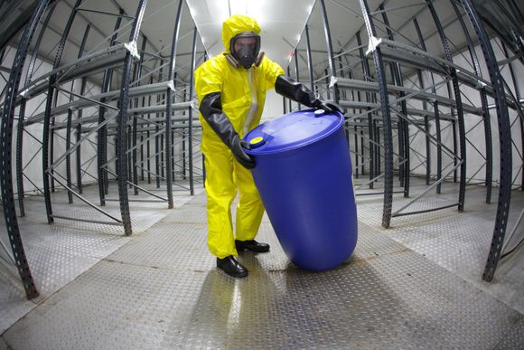 Un homme en costume jaune porte un baril bleu