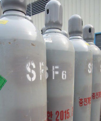 Une rangée de bouteilles de gaz est alignée devant un immeuble.