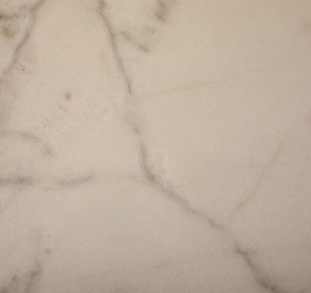Cream-colored marble with subtle brown veining, creating a smooth surface texture.
