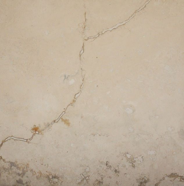 Beige wall with a large crack and discoloration along the bottom.