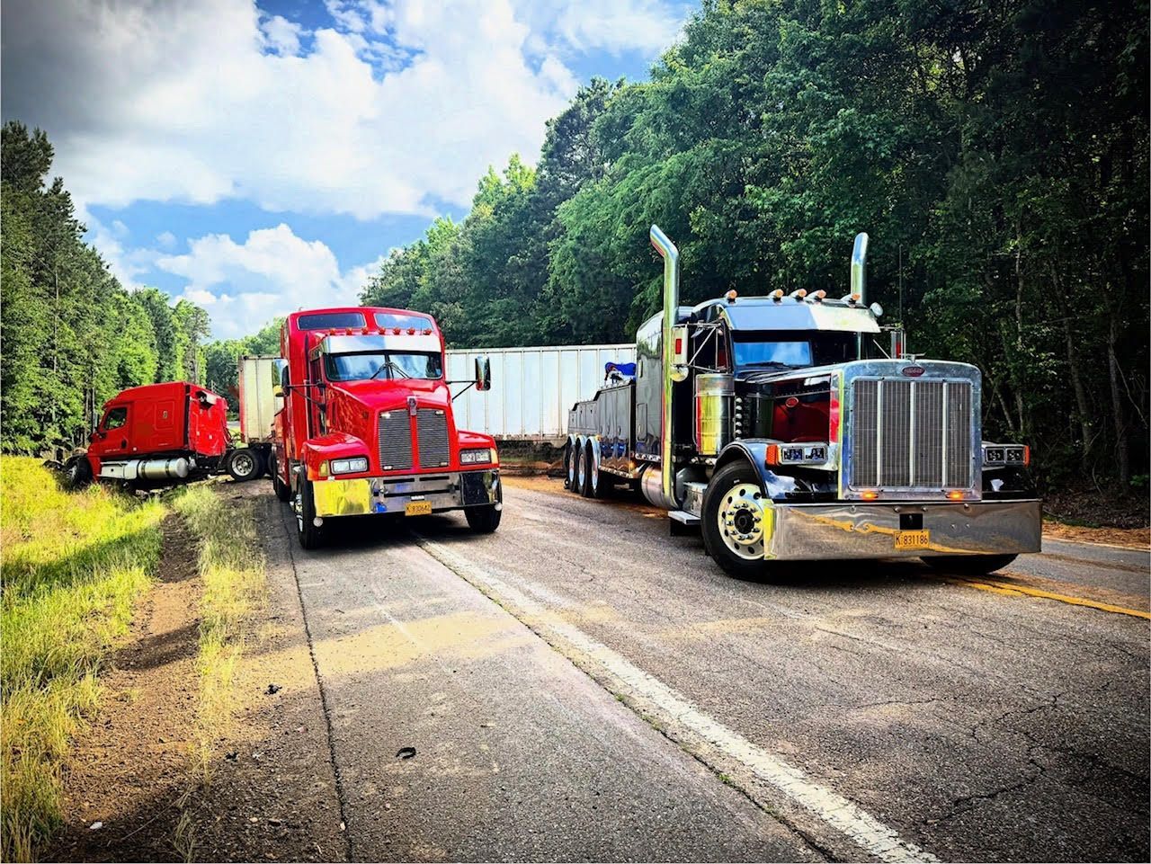 A white and blue semi truck is parked on the side of the road