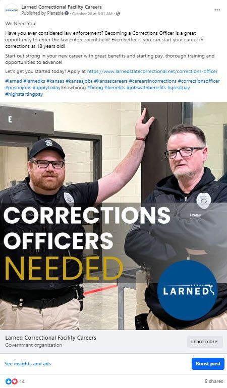 Two corrections officers are standing next to each other in front of a building.
