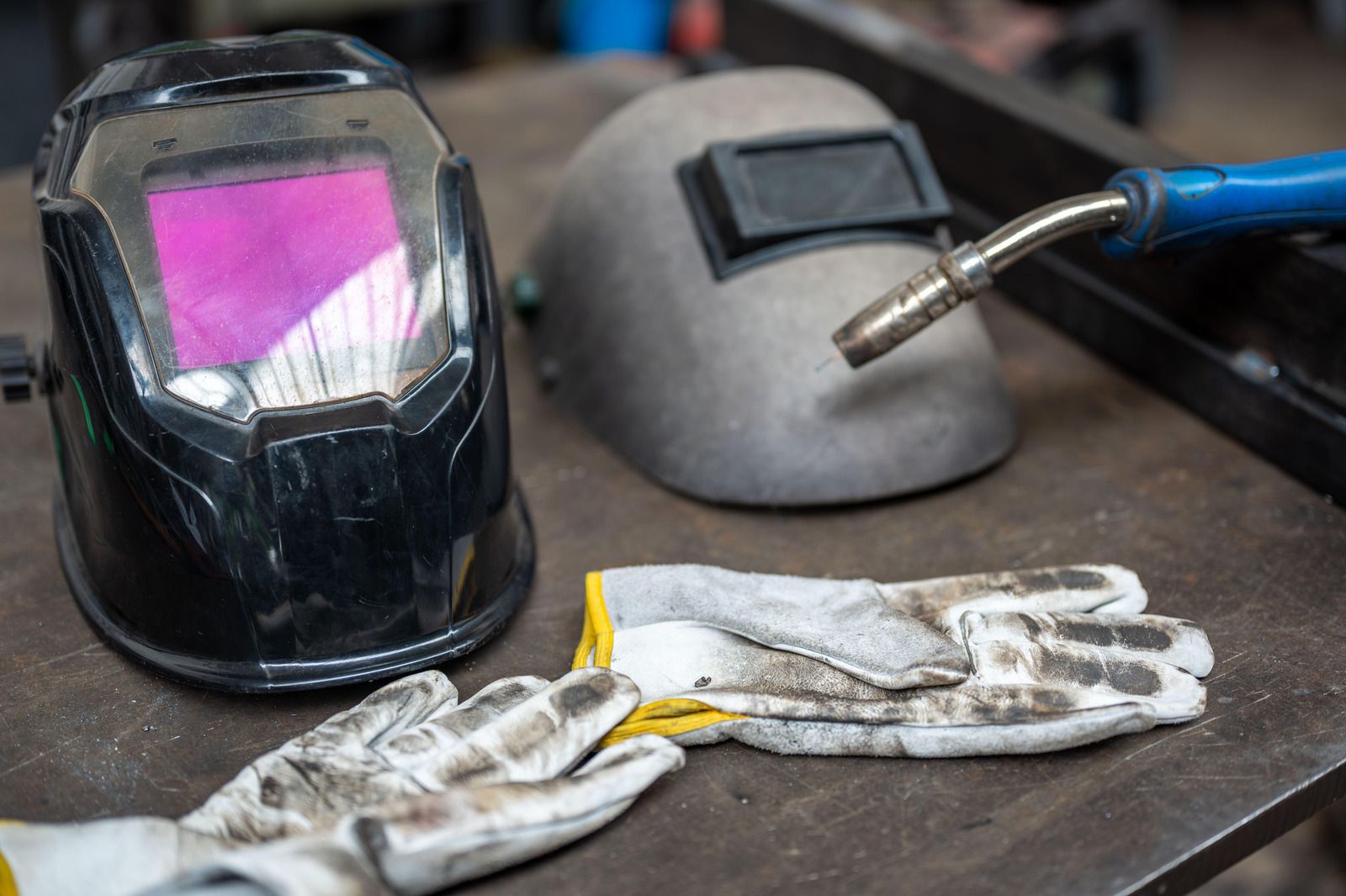 Welder using a torch, creating sparks on metal.