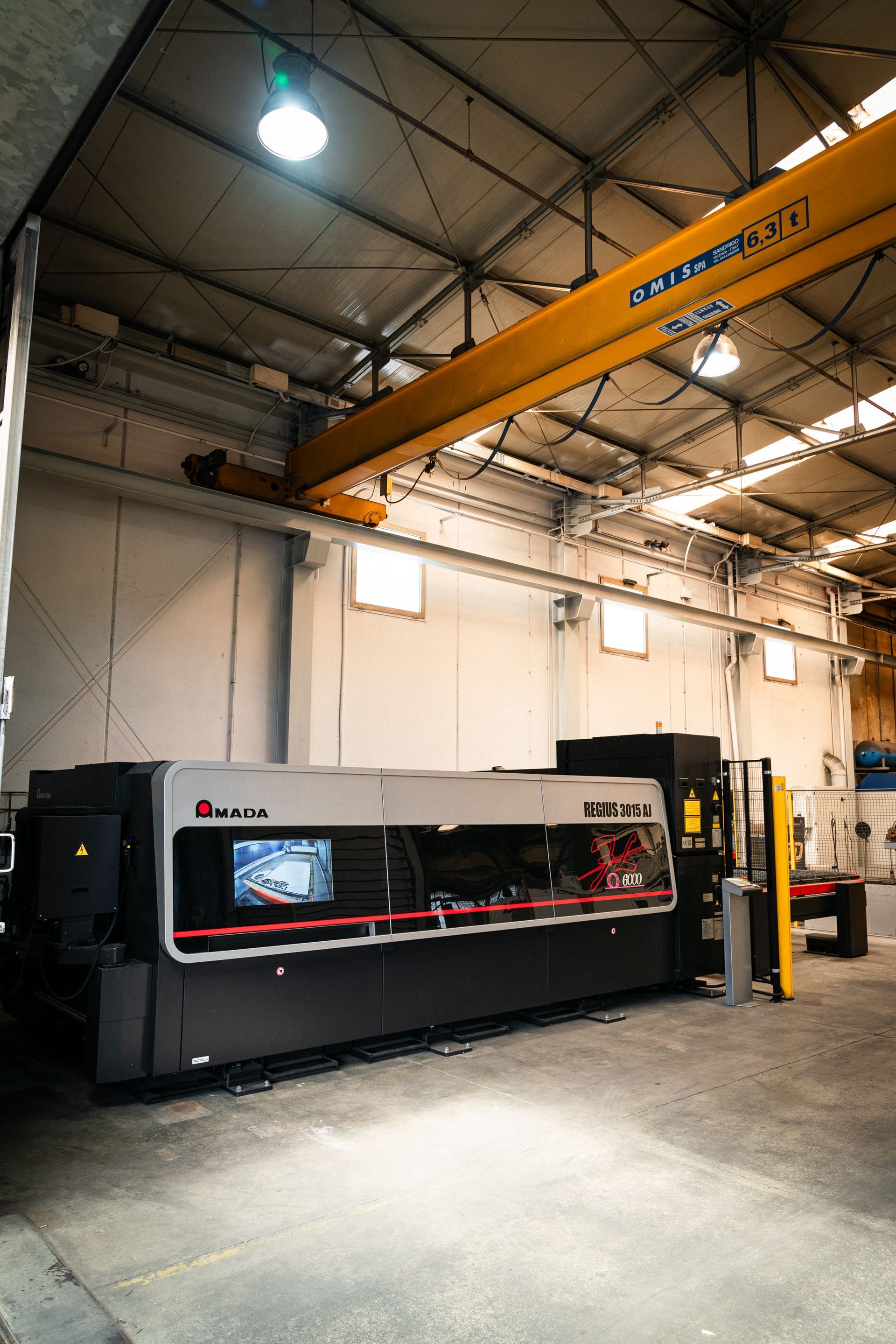 Macchina industriale per il taglio laser in una fabbrica, con una gru a ponte.