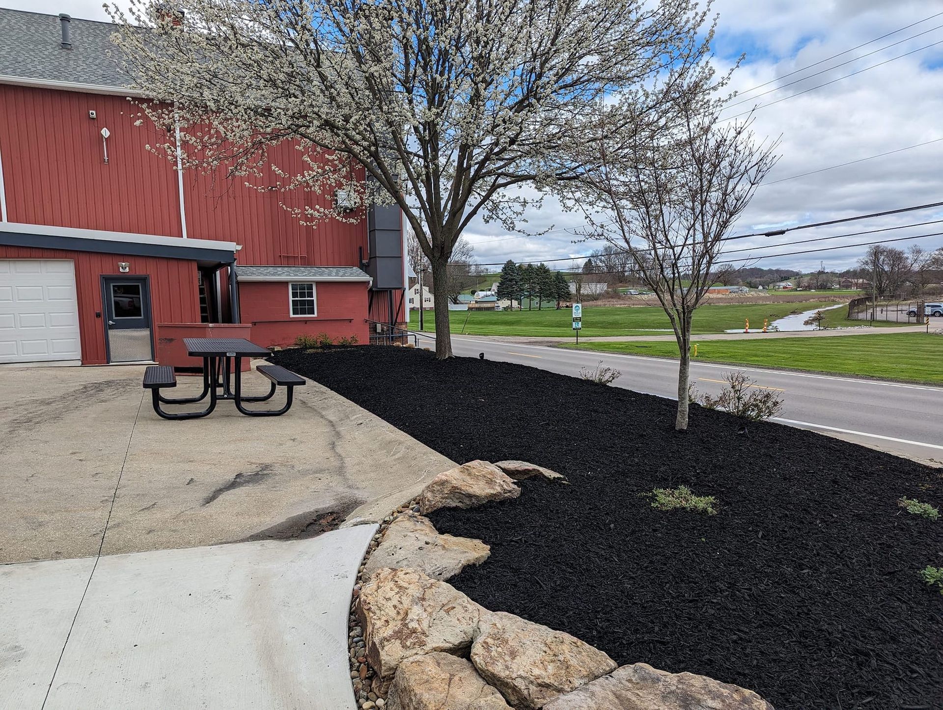 A red barn with a picnic table in front of it