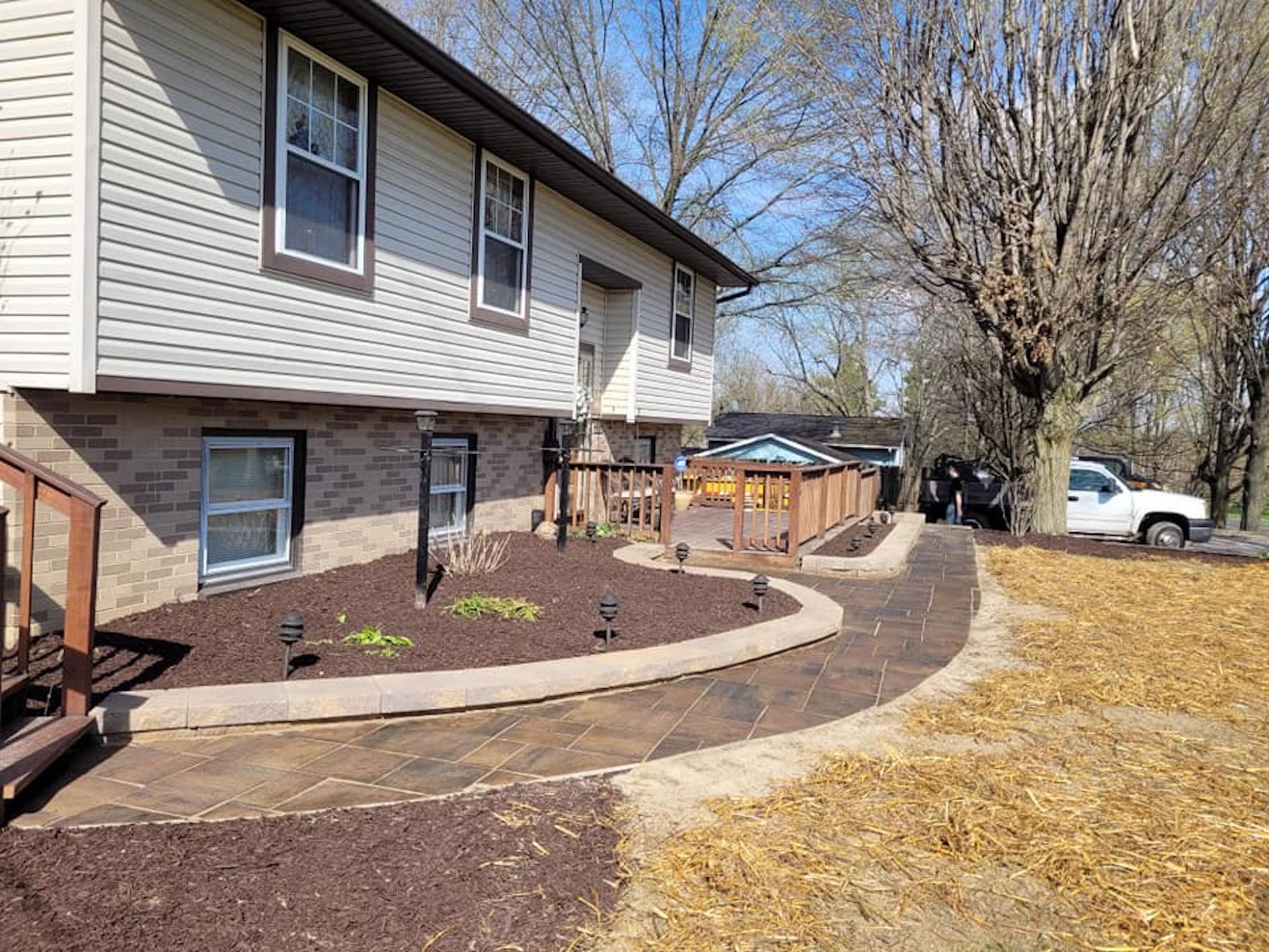 A house with a patio and a walkway in front of it.