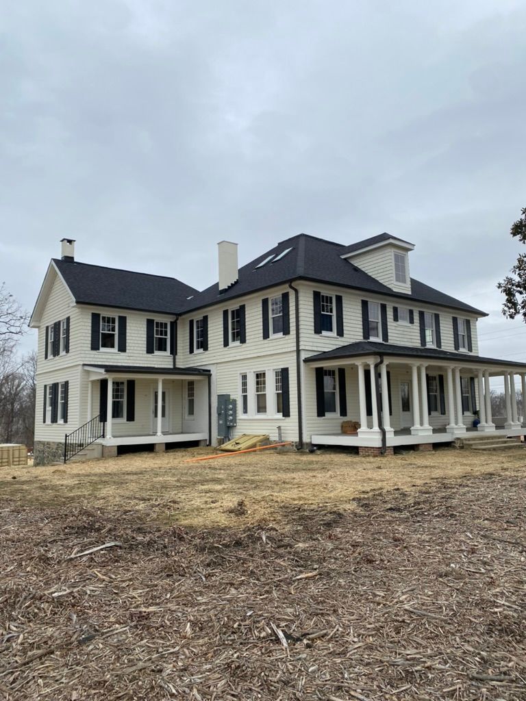 A large house is sitting on top of a lush green field.