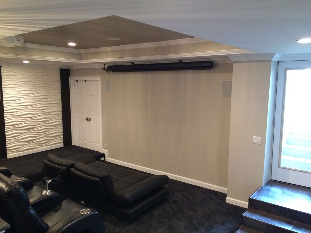 A home theater with a projector screen and black chairs