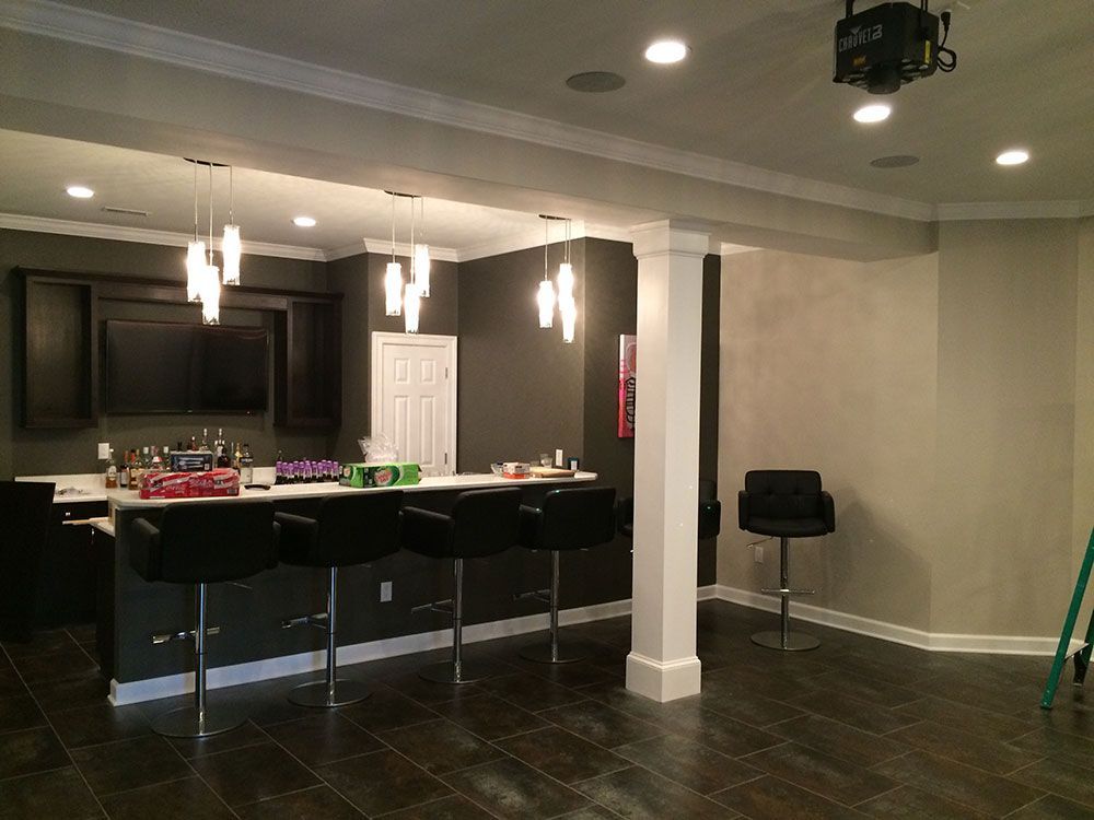 A basement with a bar and stools in it