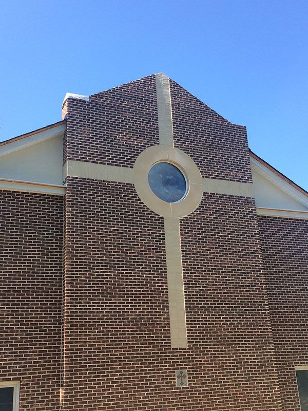 A brick building with a cross on the side of it