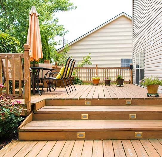 A wooden deck with a table and chairs on it