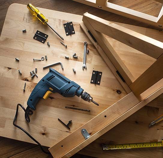 A drill is sitting on top of a wooden table