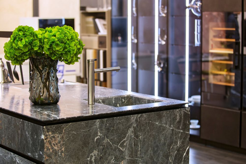 A kitchen with a sink and a vase of flowers on the counter.