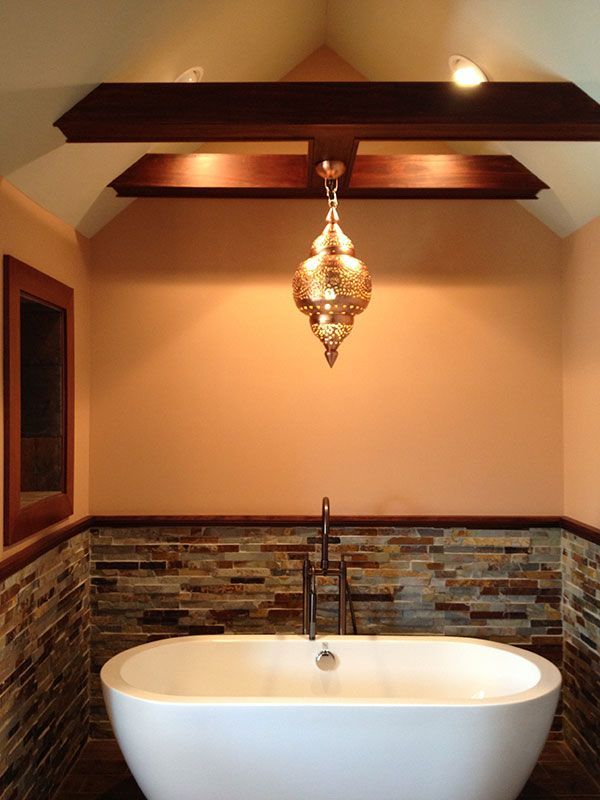 A bathroom with a bathtub and a chandelier hanging from the ceiling