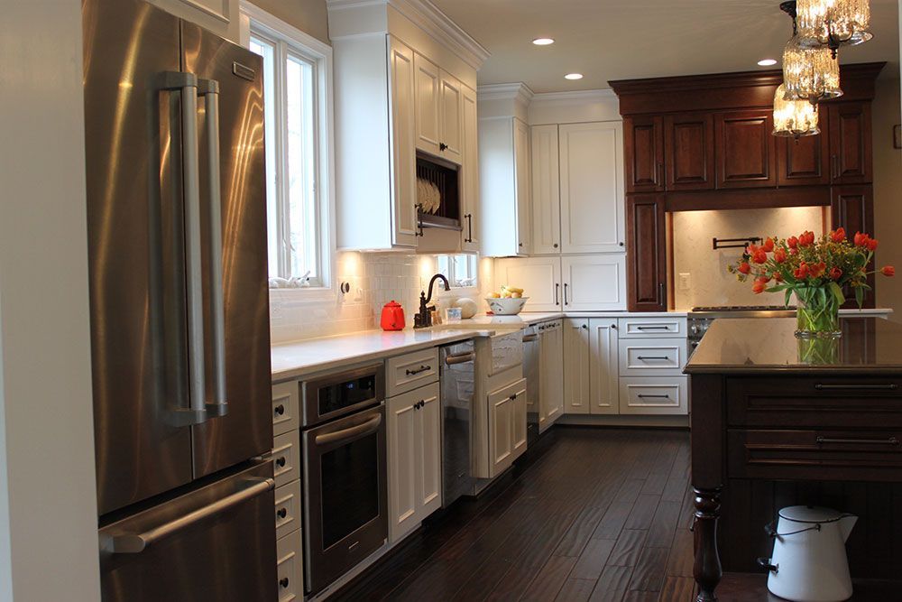 A kitchen with white cabinets , stainless steel appliances , and a large island.