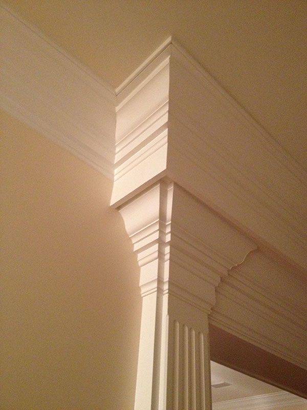 A close up of a white molding on a wall in a room.
