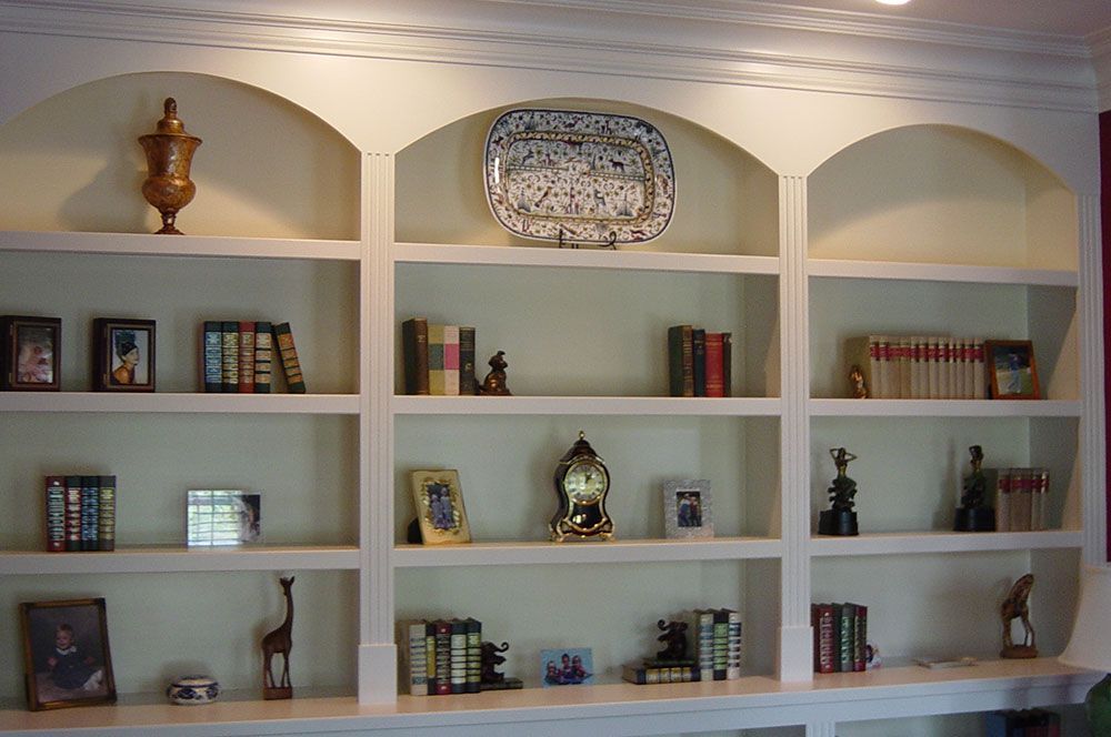A bookshelf with a plate on top of it