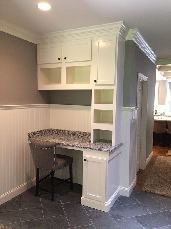There is a desk with a chair in the corner of the room.