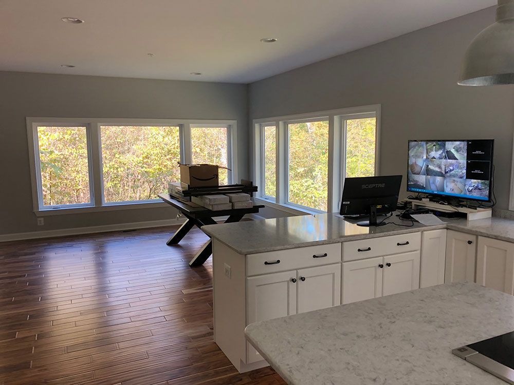 A kitchen with a lot of windows and a computer on the counter.