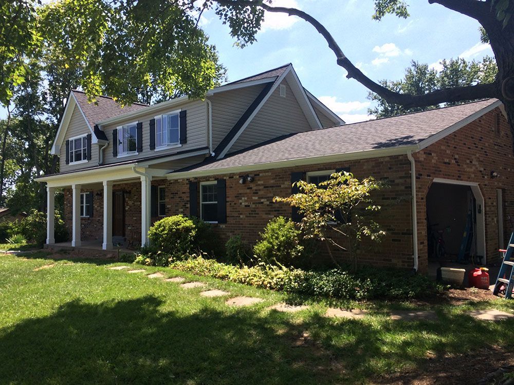 A large brick house with a large porch and a garage