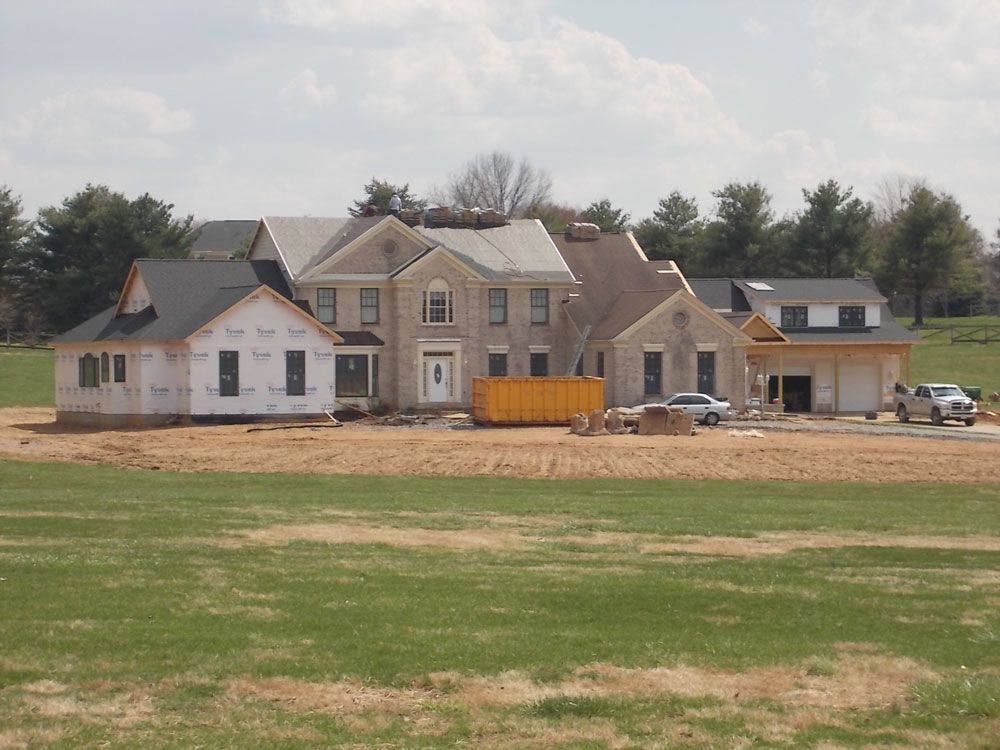 A large house is being built in the middle of a field
