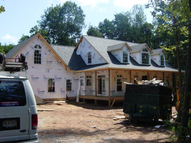 A ford van is parked in front of a house under construction