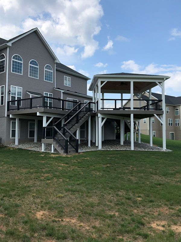 The back of a house with a large deck and stairs.