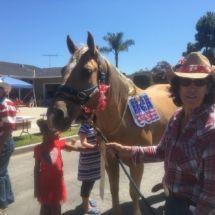 A woman and two children are standing next to a horse.