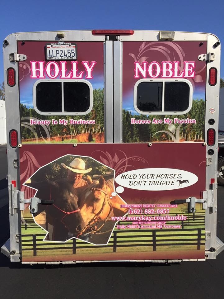 The back of a trailer with a picture of a man riding a horse on it.