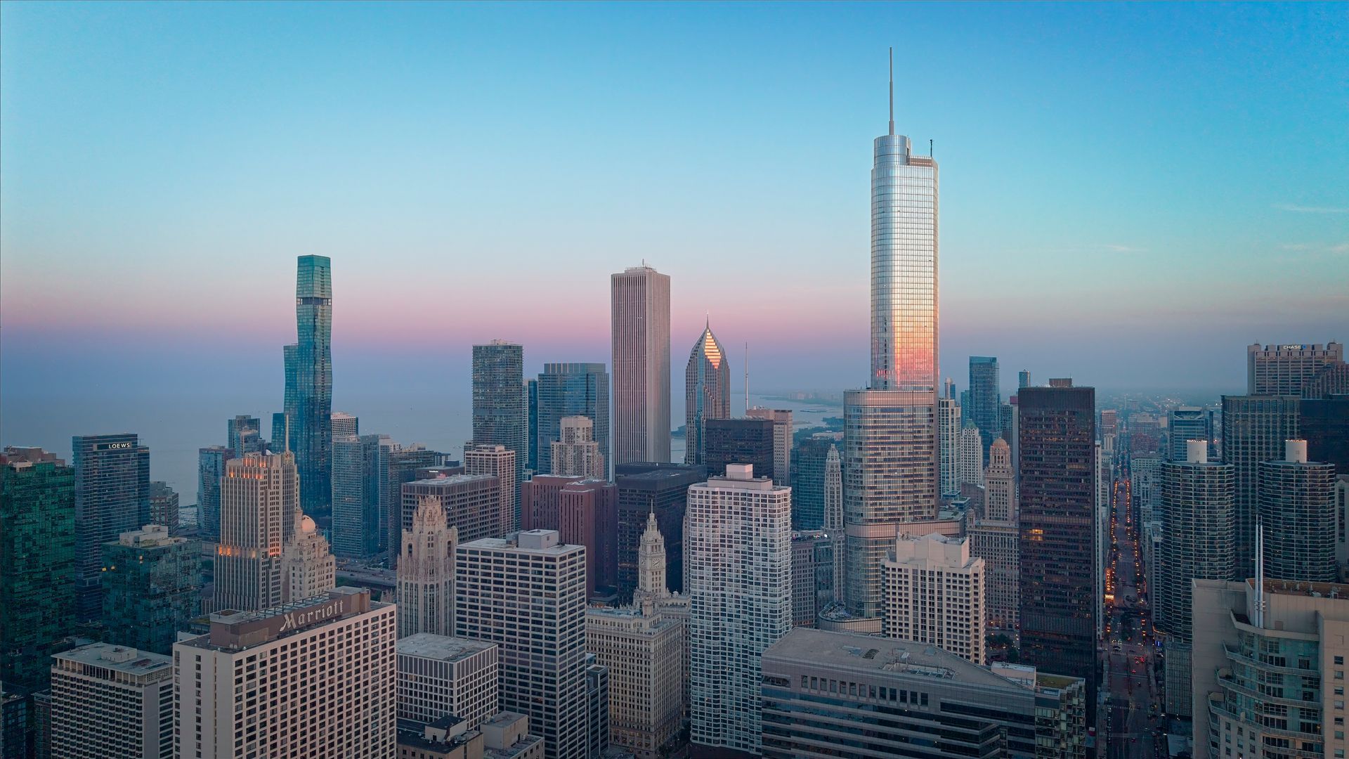 City skyline at dusk with modern skyscrapers under a pink-and-blue sky