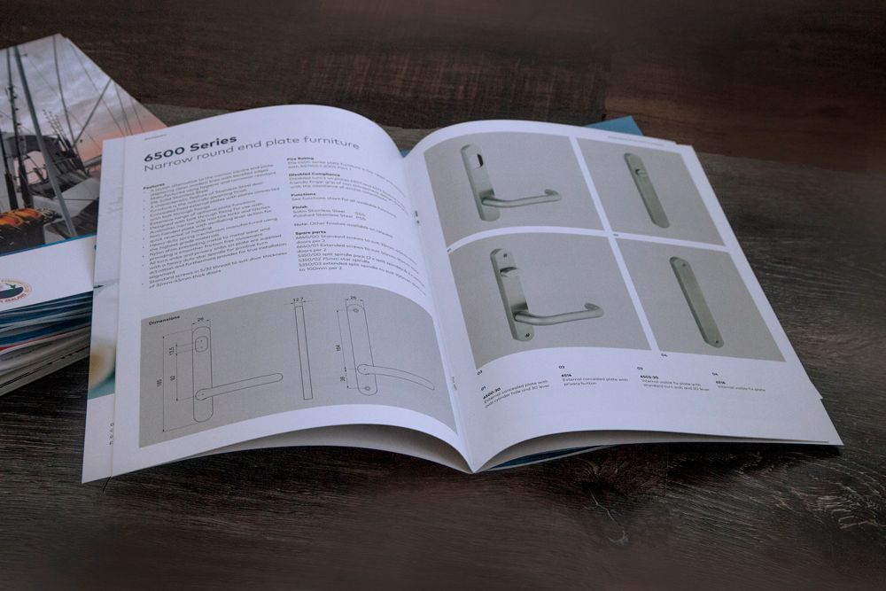 Open book with product diagrams and hardware photos, on a wooden surface.